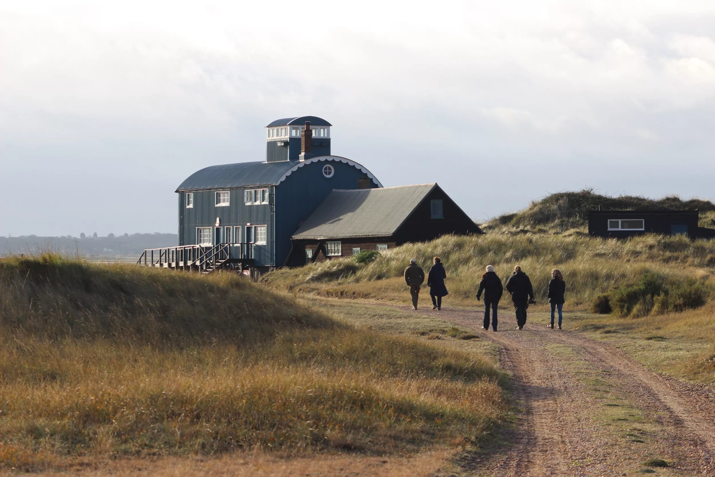 Visitors walking towards the Old Lifeboat Station at Blakeney National Nature Reserve