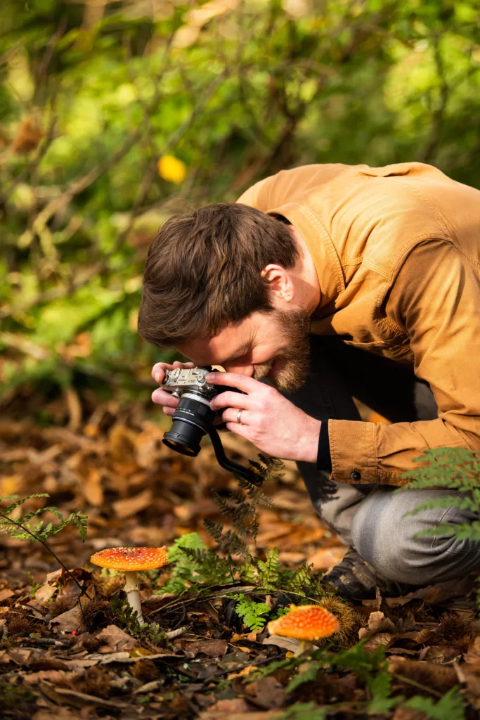 Man taking photo of autumn leaves