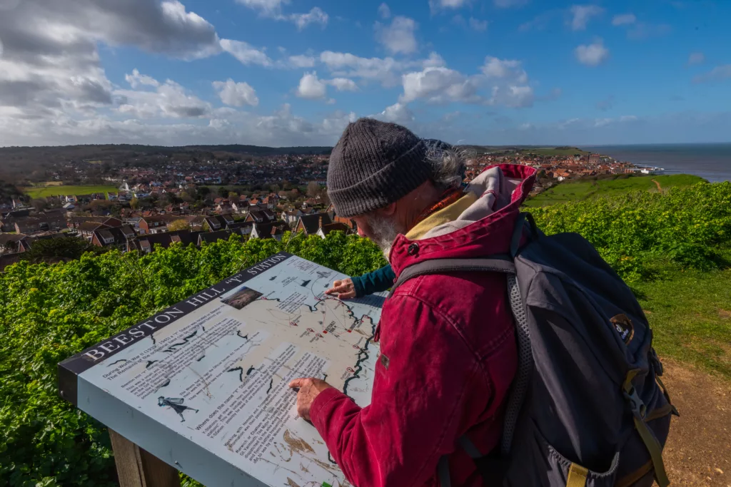 Man reading information board at Beeston Bump