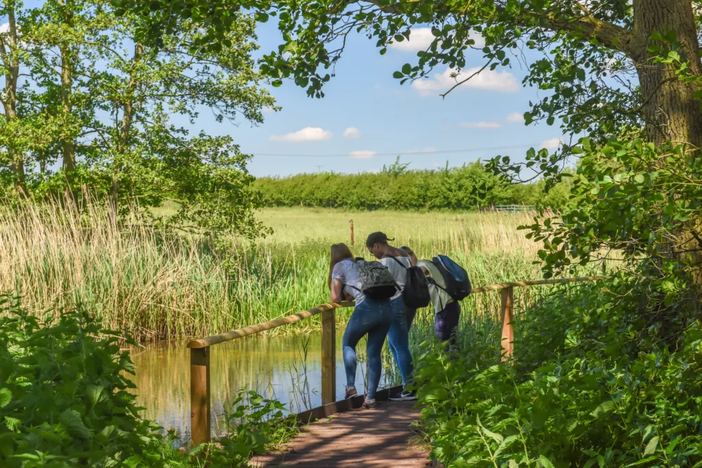 Two girls on a boardwalk beside a river