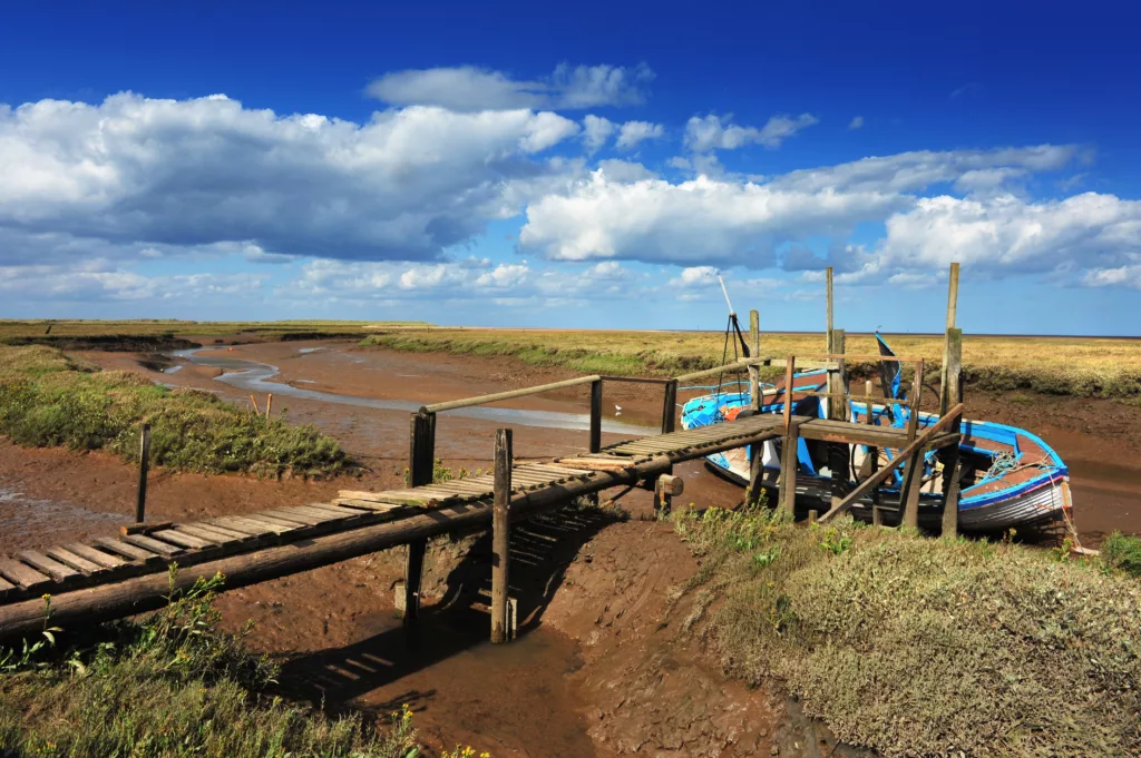 A boat jetty and boat moored at low tide