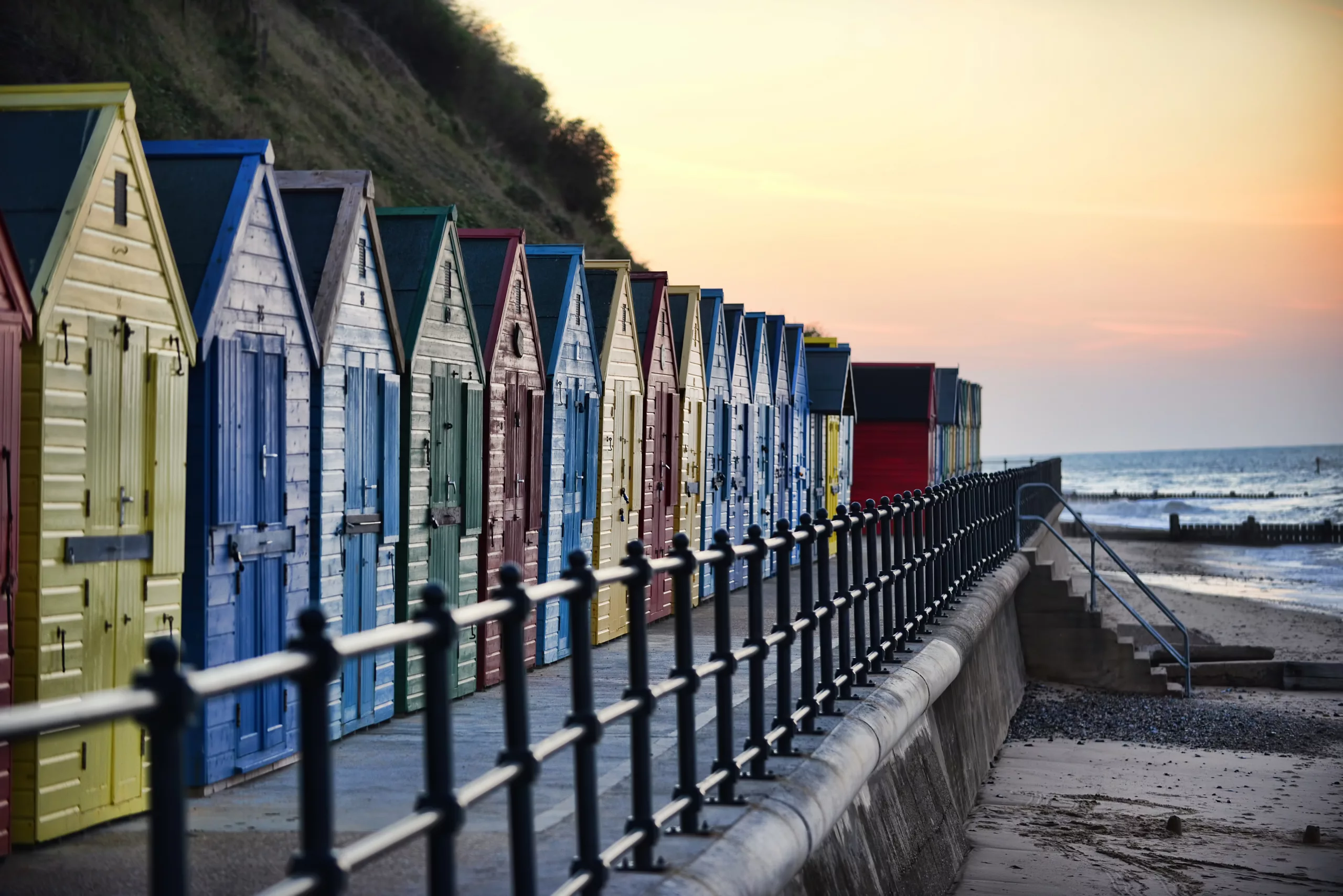 Multi-coloured beach huts at sunset