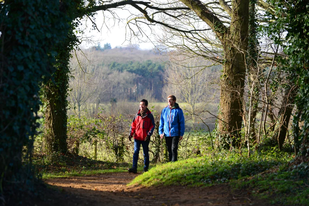 Two men walking along a woodland path