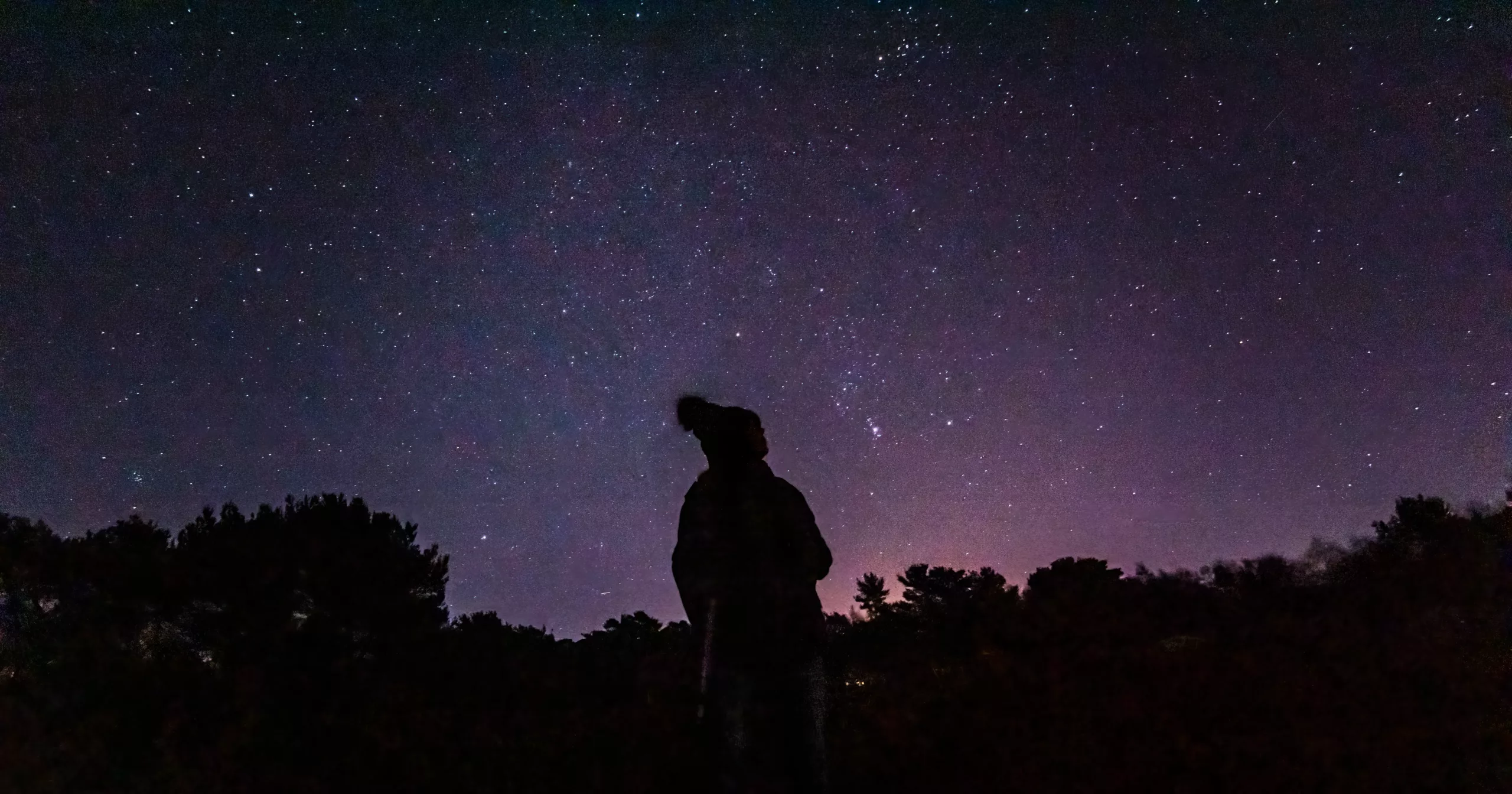Silhouetted person stargazing in Kelling