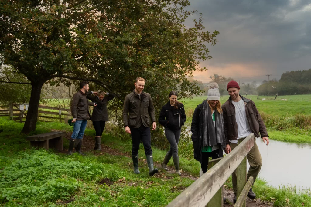A group of people walking alongside a river